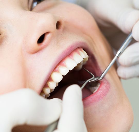 Closeup of woman smiling during dental exam