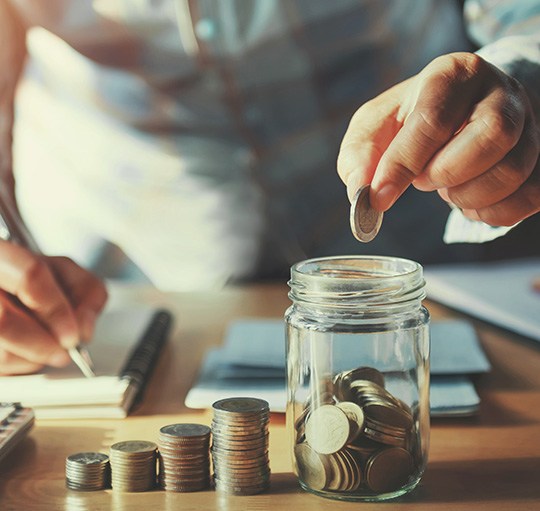 Someone putting coins into a jar